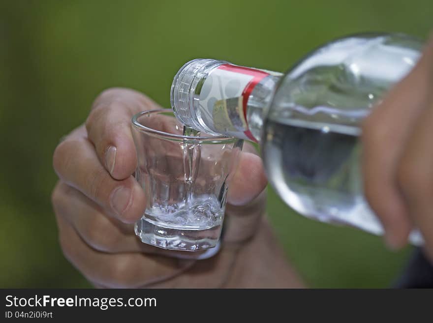 Color photo of a glass cup with liquor. Green background. Color photo of a glass cup with liquor. Green background.