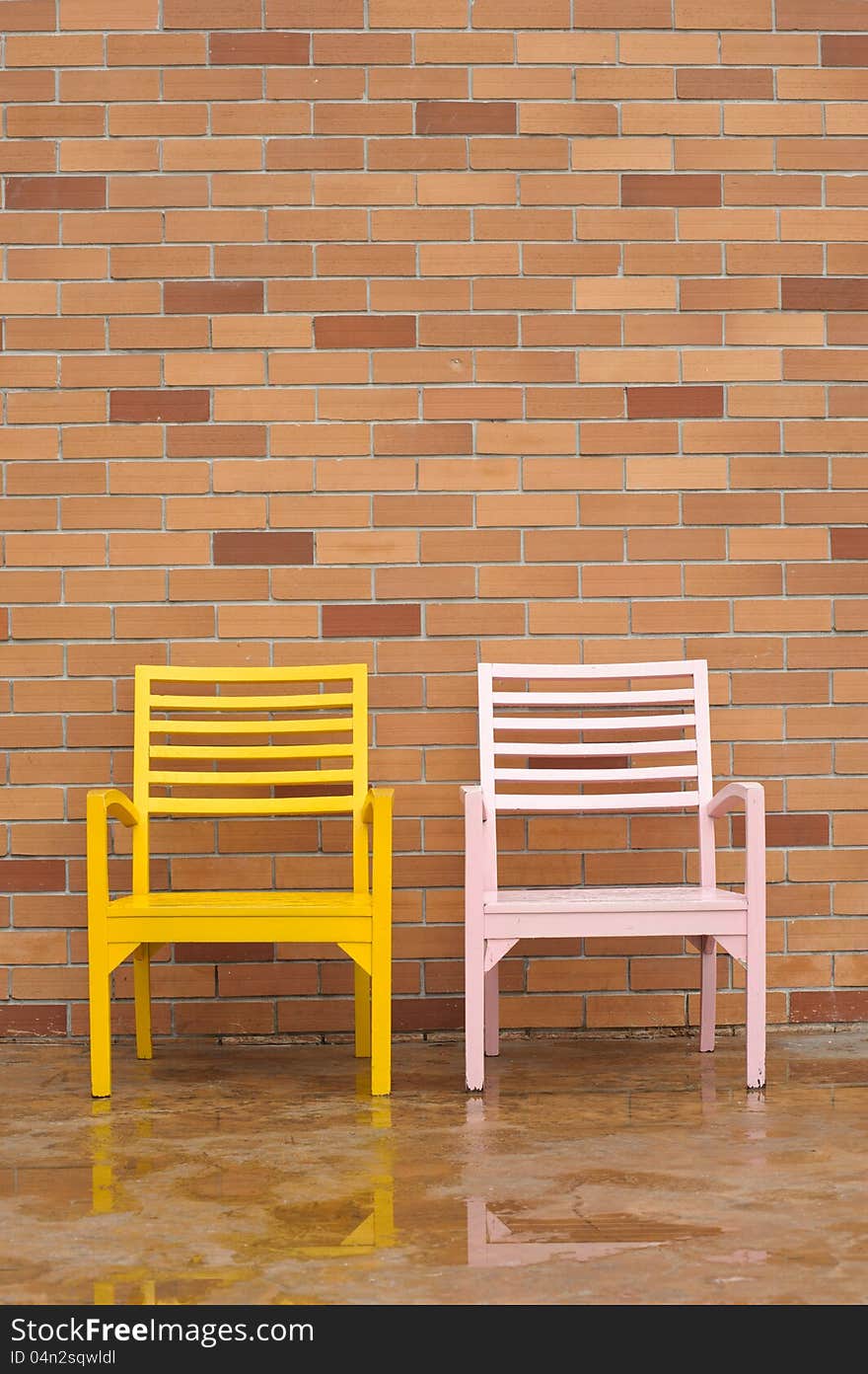 Bricyellow and pink chairs on ancient red brick