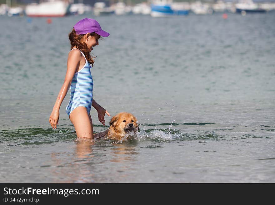 Cute girl and her Elo (German dog breed) puppy playing in the water and the puppy learns to swim. Cute girl and her Elo (German dog breed) puppy playing in the water and the puppy learns to swim