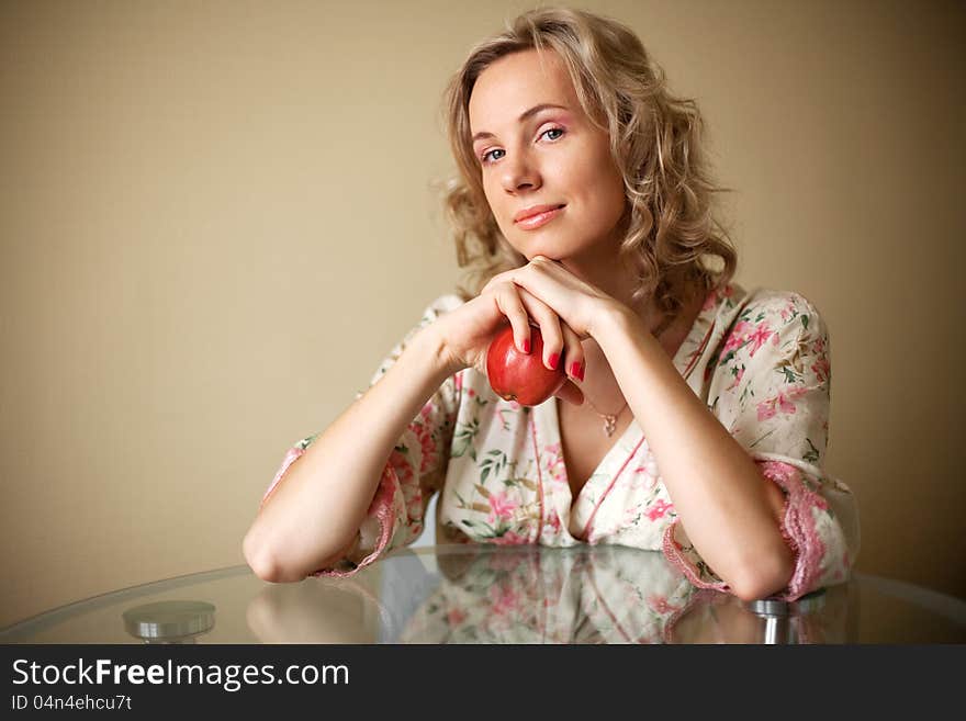 The Girl with apple sitting at the table