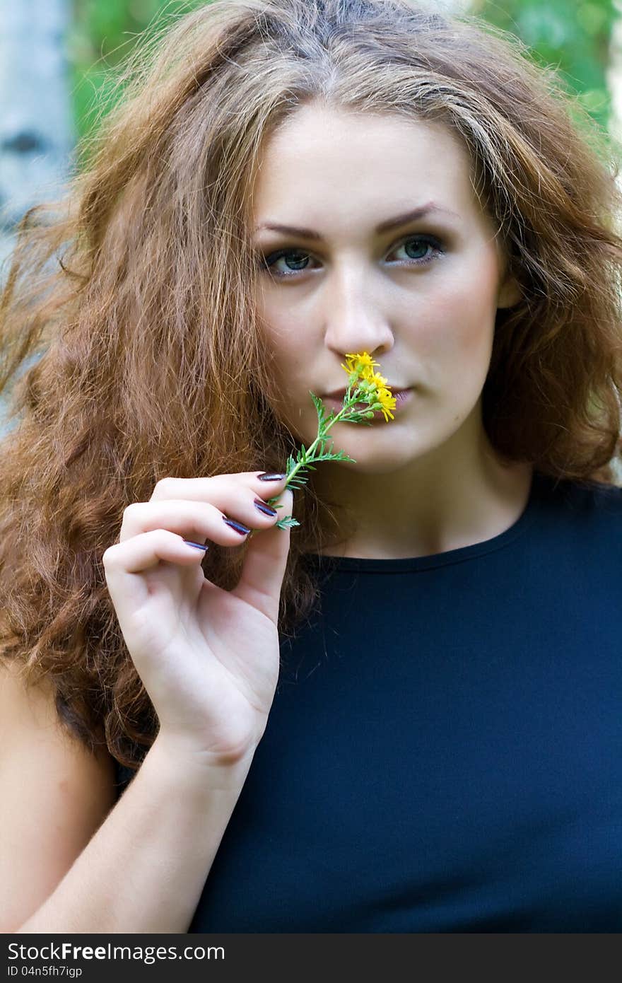 Portrait of a beautiful girl with a yellow flower. Portrait of a beautiful girl with a yellow flower