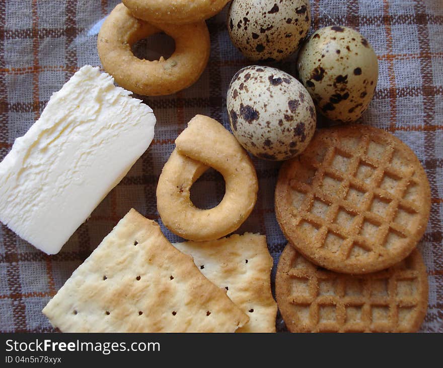 Quail eggs, butter and biscuits on a transparent plate, sitting on a napkin. Quail eggs, butter and biscuits on a transparent plate, sitting on a napkin