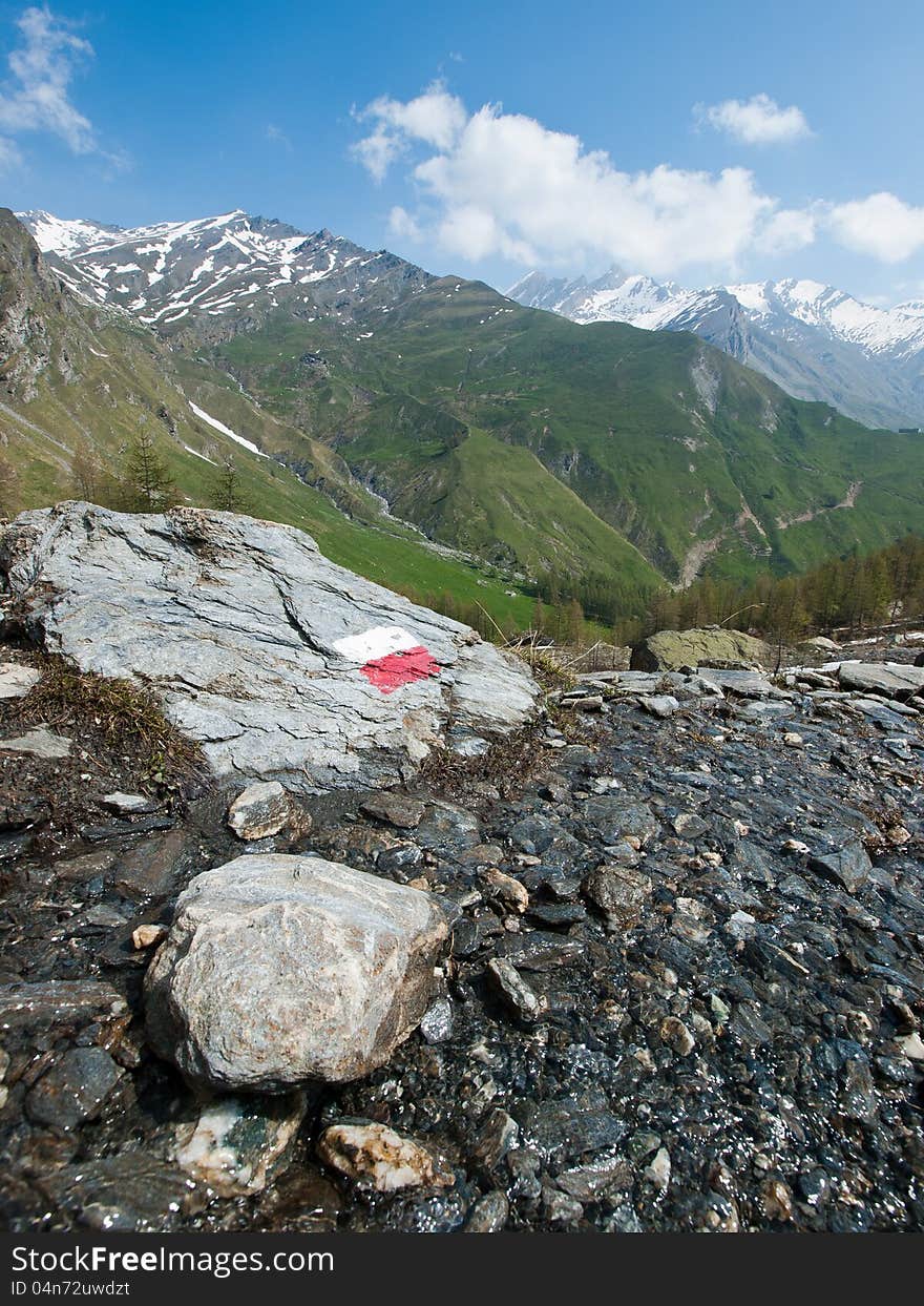 An indication on a rock to show the right direction on a mountain path. It can be used as a concept related to finding your own way and more. An indication on a rock to show the right direction on a mountain path. It can be used as a concept related to finding your own way and more.