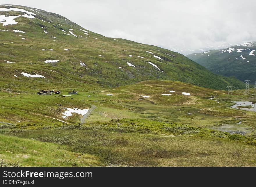 Norwegian landscape with a mountain on background.