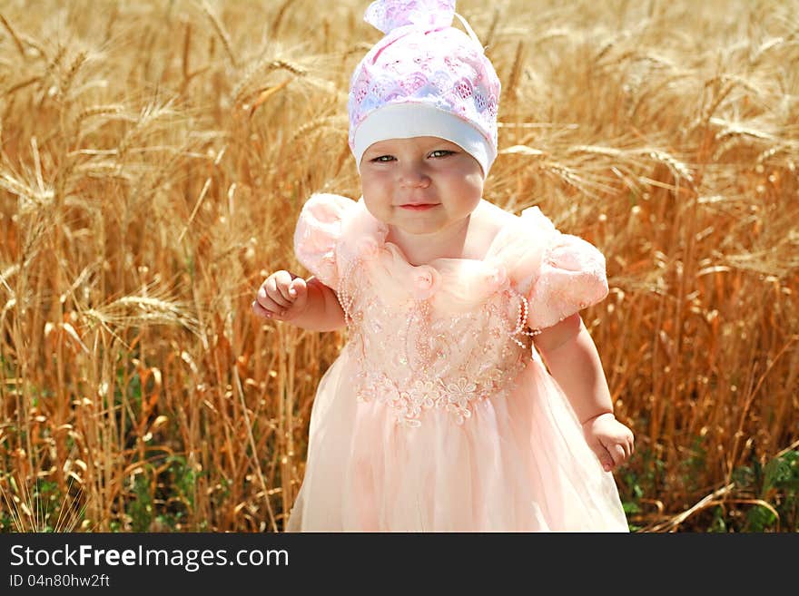 Portrait of little child girl in wheat field alone, in white hat