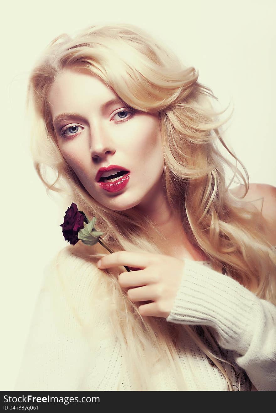 Pretty female face. Blond long hair. Red flower