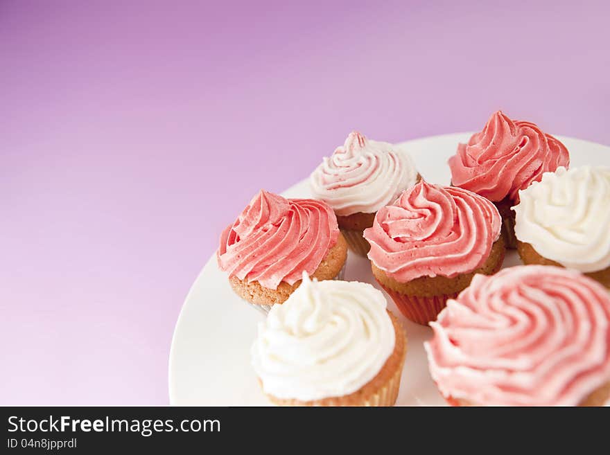 Homemade pink and white cupcakes on the white plate