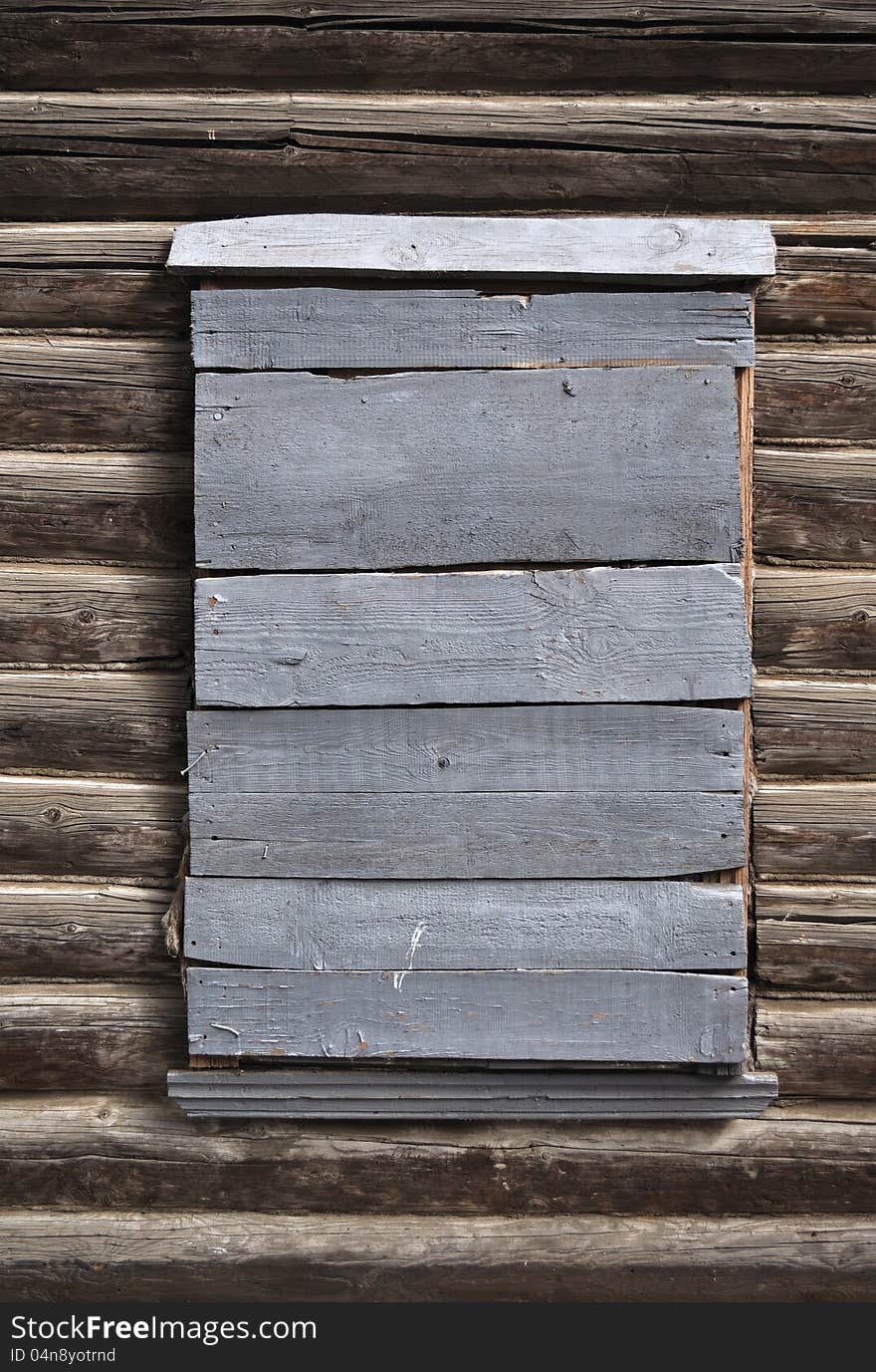 Boarded-up window in a wooden house