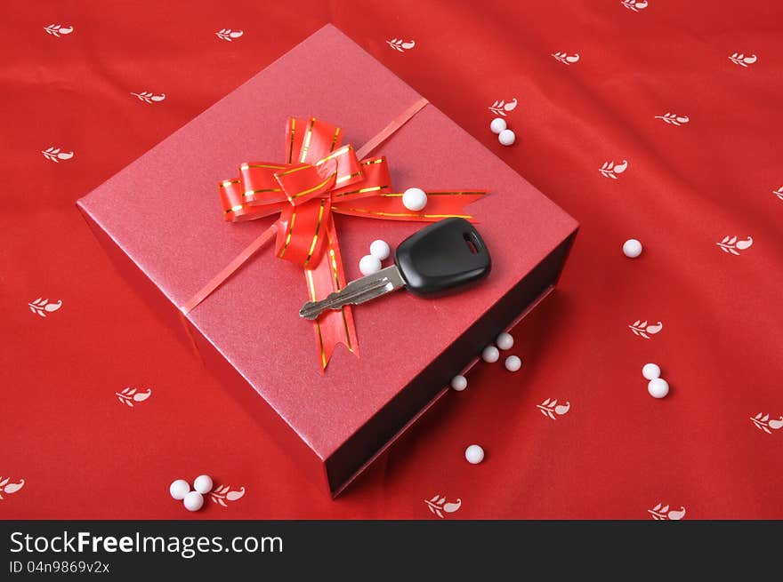 Car keys and gift box on red background