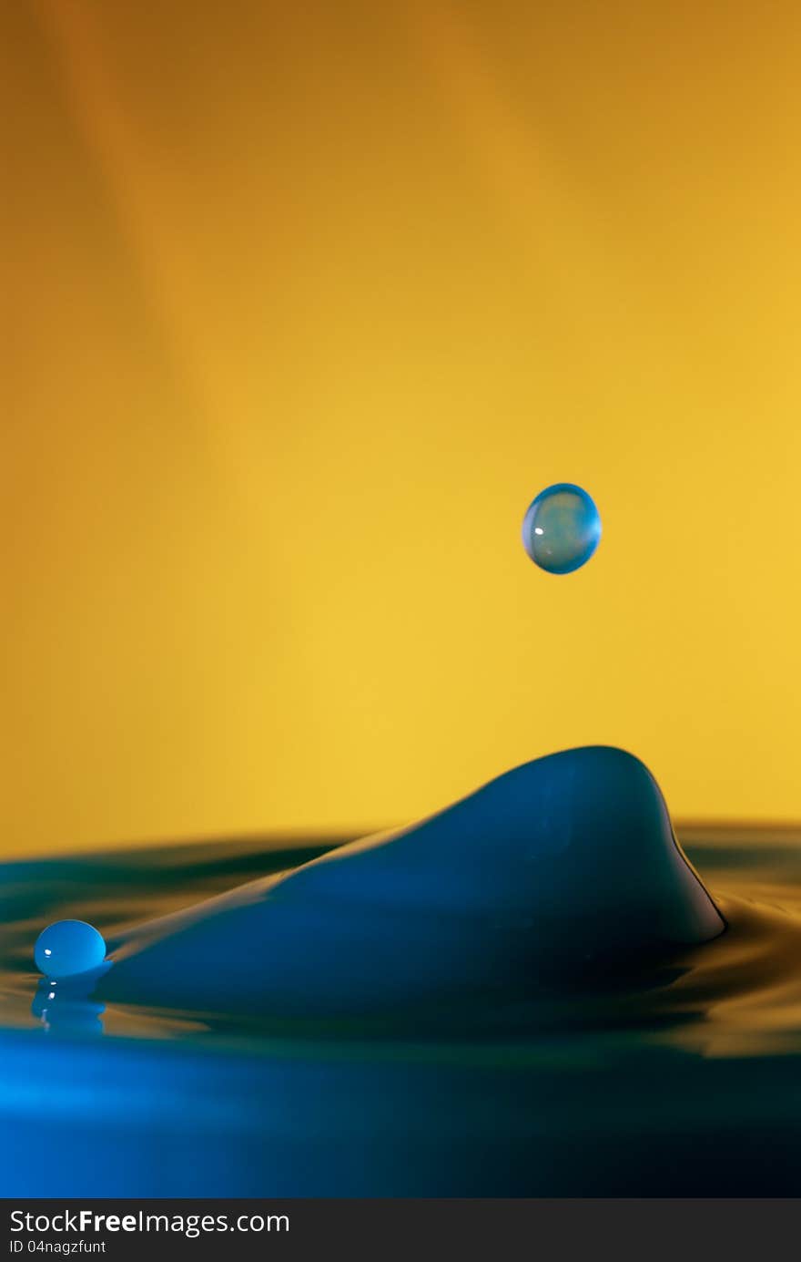 Drop of water falling into blue wate, macro. Drop of water falling into blue wate, macro