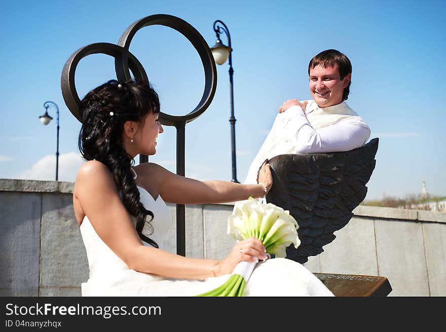 Bride and groom on bronze bench