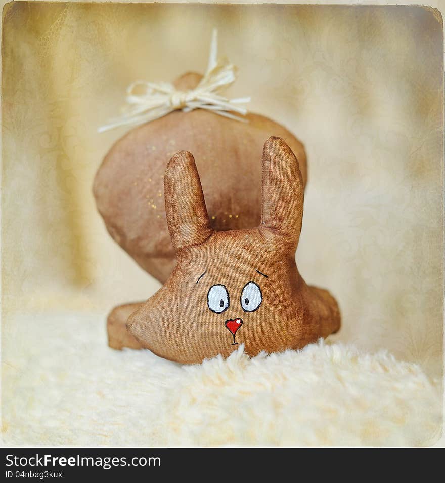 On a light background a toy hare with a wonderful attractive face