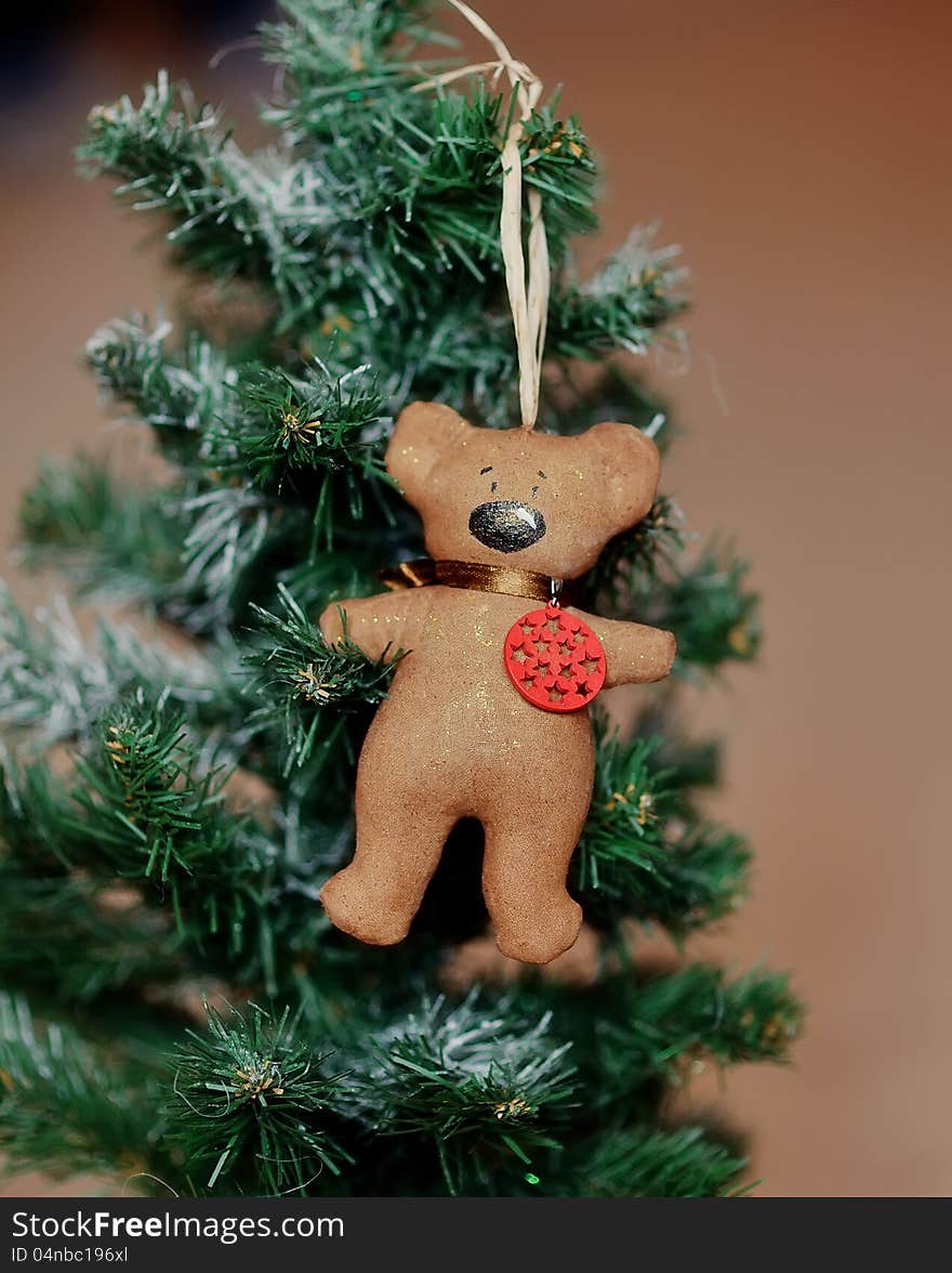 On a green fir-tree the brown bear hangs. On a green fir-tree the brown bear hangs