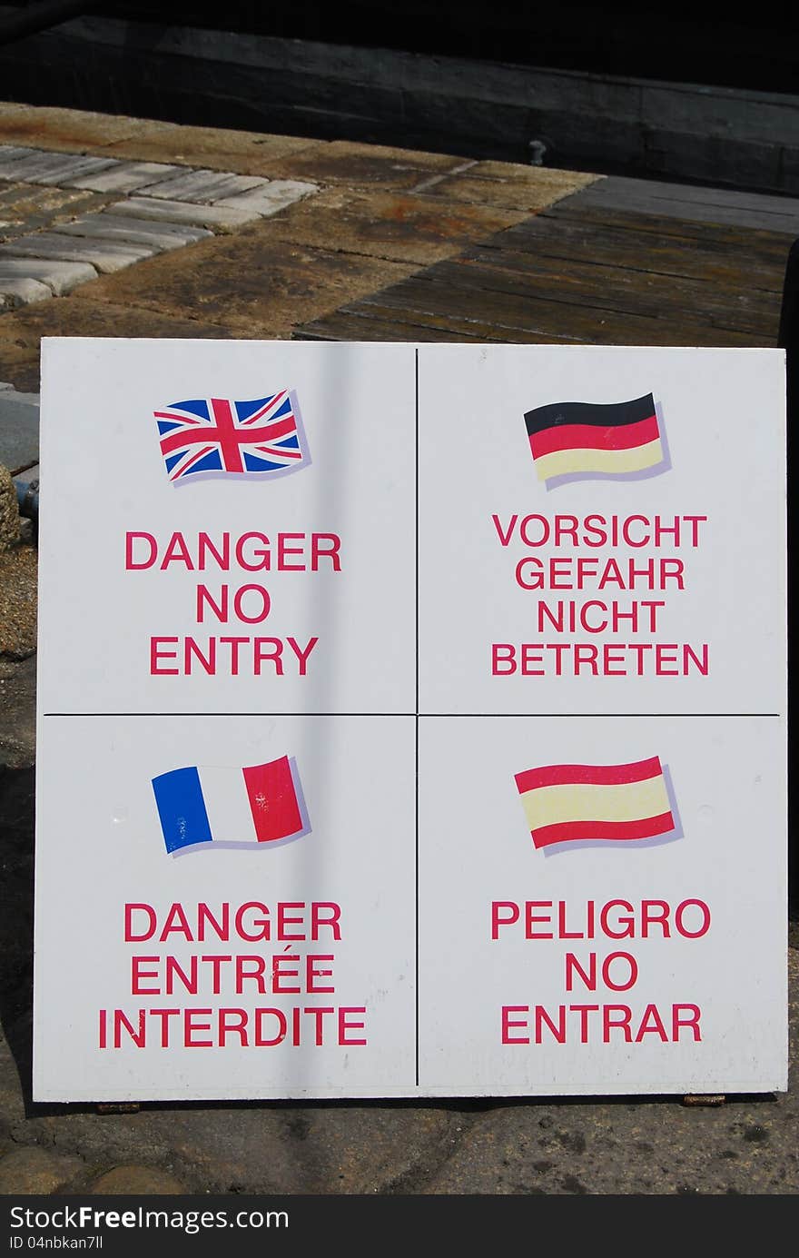 Multi-lingual danger signs on quay at Portsmouth England. Multi-lingual danger signs on quay at Portsmouth England