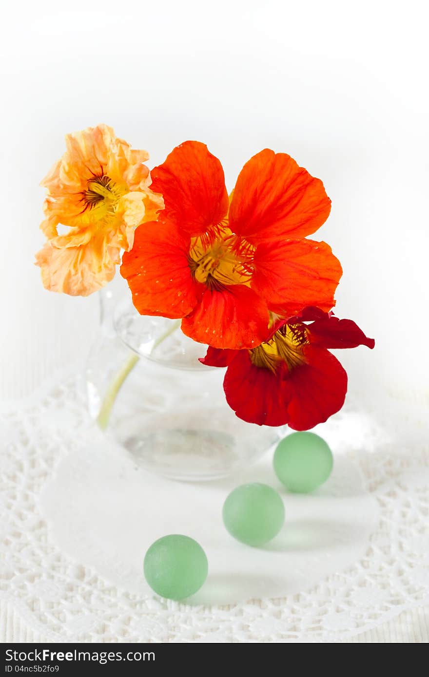 A bouquet of flowers of nasturtium and decorative glass balls green. A bouquet of flowers of nasturtium and decorative glass balls green