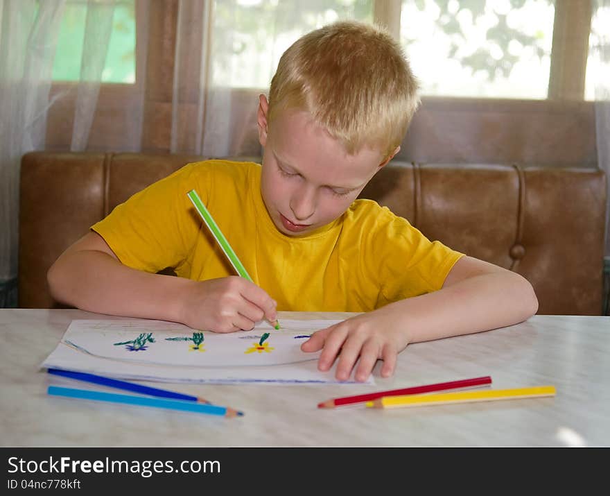 Young boy drawing positive picture with pencils