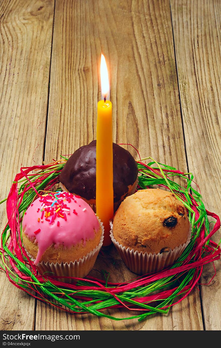 Three cupcakes and a burning candle