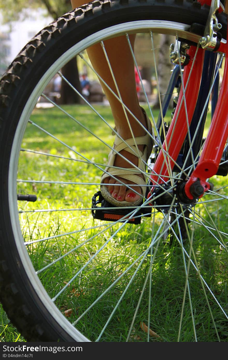 Close-up picture of a bicycle with a woman's foot, detail. Close-up picture of a bicycle with a woman's foot, detail