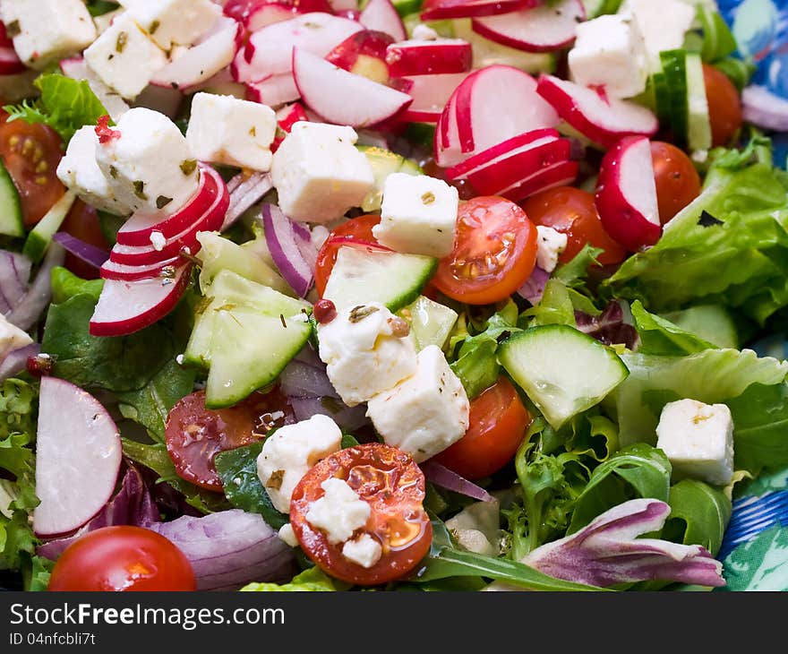 Fresh summer salad with feta cheese, cucumber, cherry tomatoes and radishes.