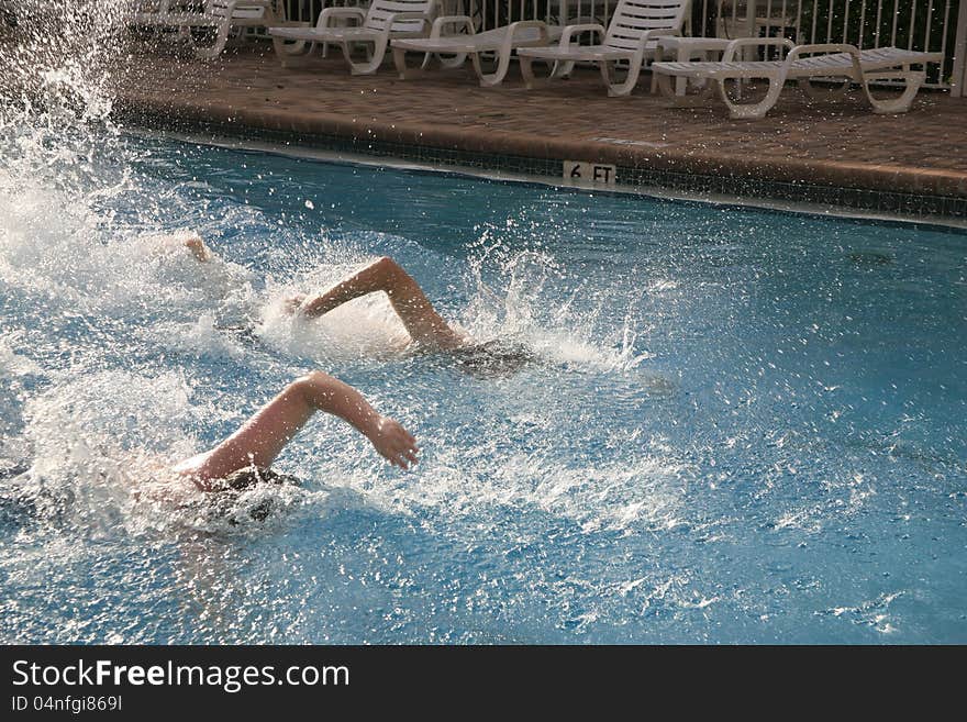 Swimmers racing to the finish line. Arms in the air, lots of splashing water. Swimmers racing to the finish line. Arms in the air, lots of splashing water