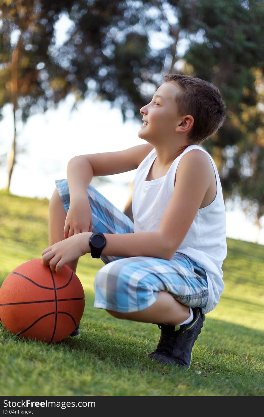 Boy with a ball in the fresh air in the park summer