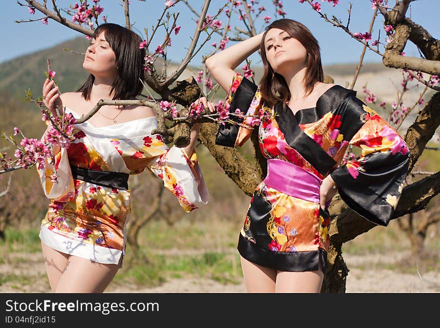 Girls in kimono and flowerses of the peach. Girls in kimono and flowerses of the peach