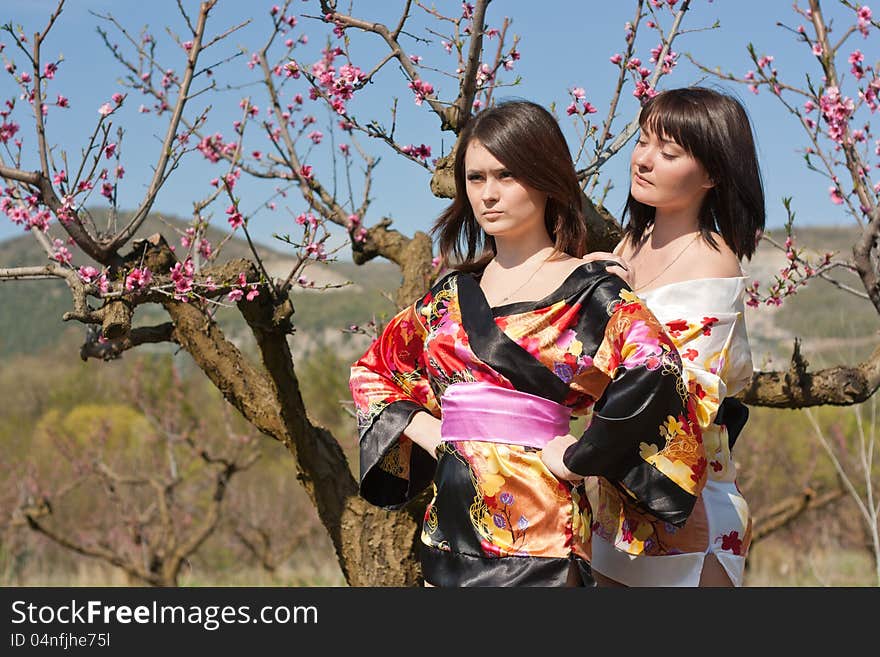 Girls in kimono and flowerses of the peach. Girls in kimono and flowerses of the peach