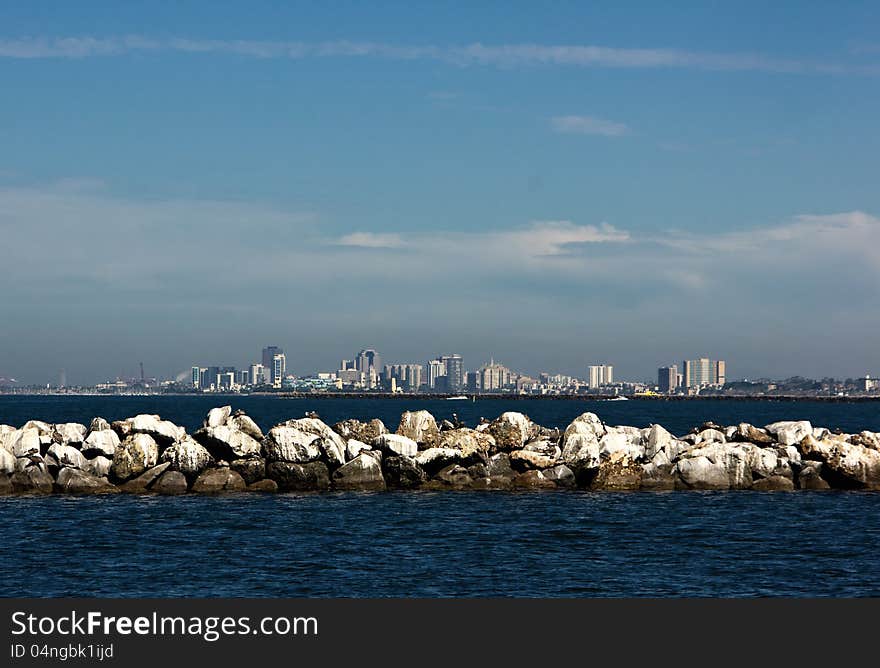 Rock jetty with cityscape of Long Beach in the background. Rock jetty with cityscape of Long Beach in the background