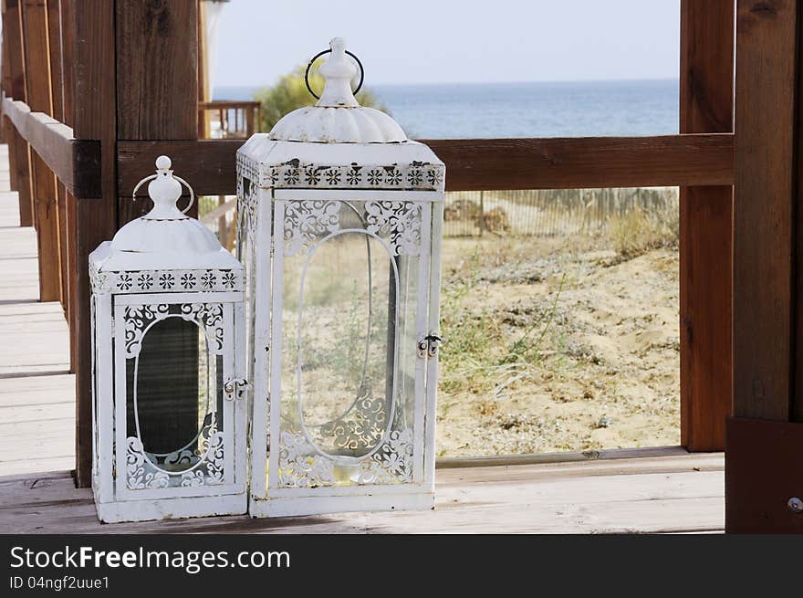 Candle lantern on a wooden deck  at the beach, Algarve, Portugal. Candle lantern on a wooden deck  at the beach, Algarve, Portugal..