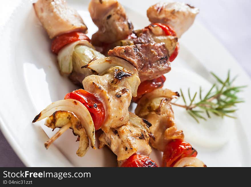 Chicken and bacon sticks with onion and tomatoes.