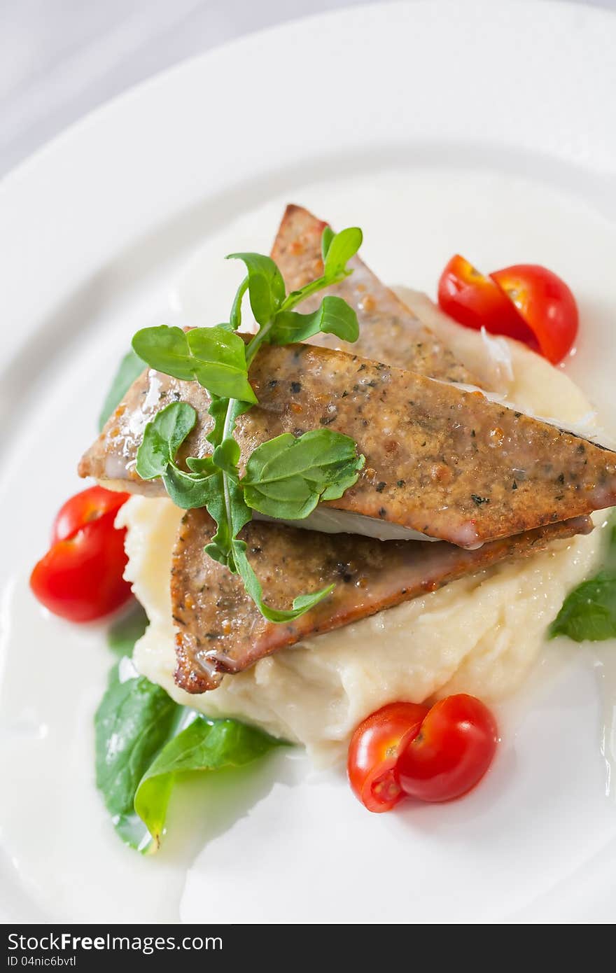 Biscuits served with potato mash and tomatoes.