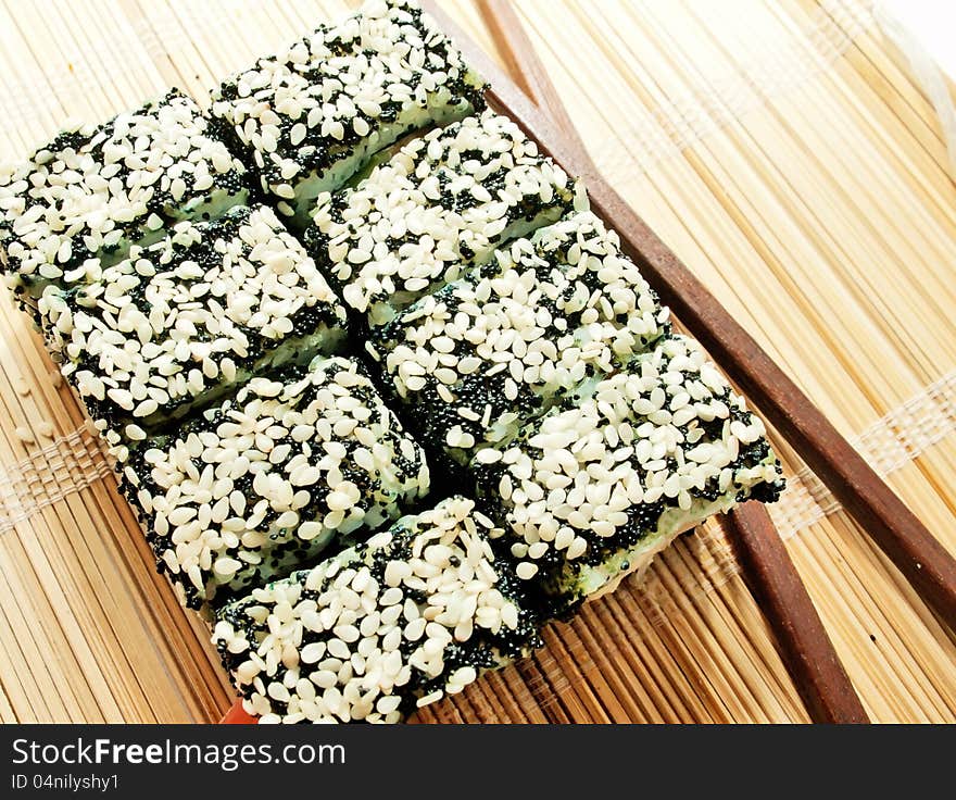 Sushi rolls with black roe and sesame on bamboo mat