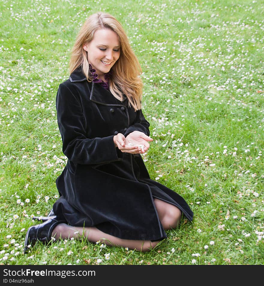 A beatiful young girl looking at daisies in her hands. A beatiful young girl looking at daisies in her hands.