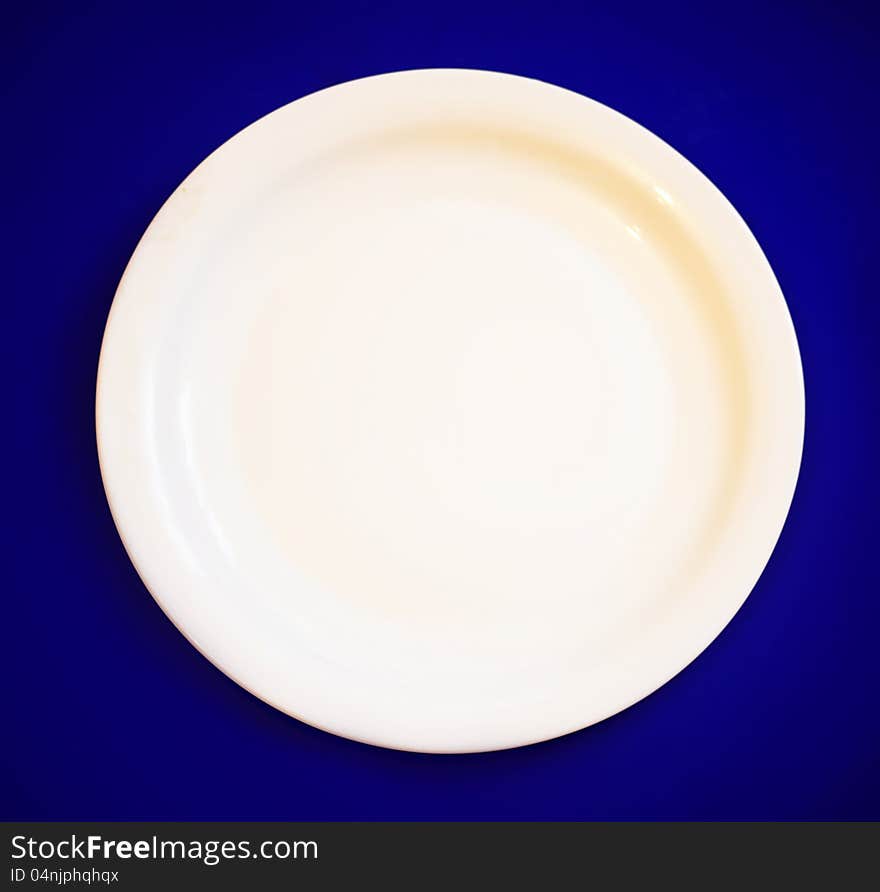 An empty plate on blue background. An empty plate on blue background.