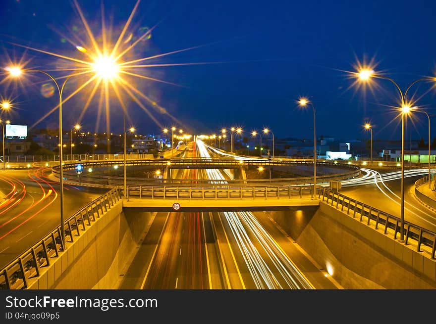 Trails of passing cars on and under roundabout. Trails of passing cars on and under roundabout