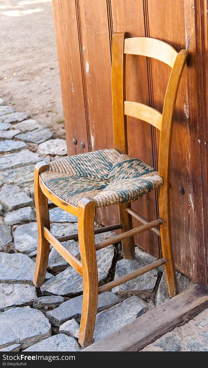 Traditional Mediterranean chair on a stone path near the gate. Traditional Mediterranean chair on a stone path near the gate