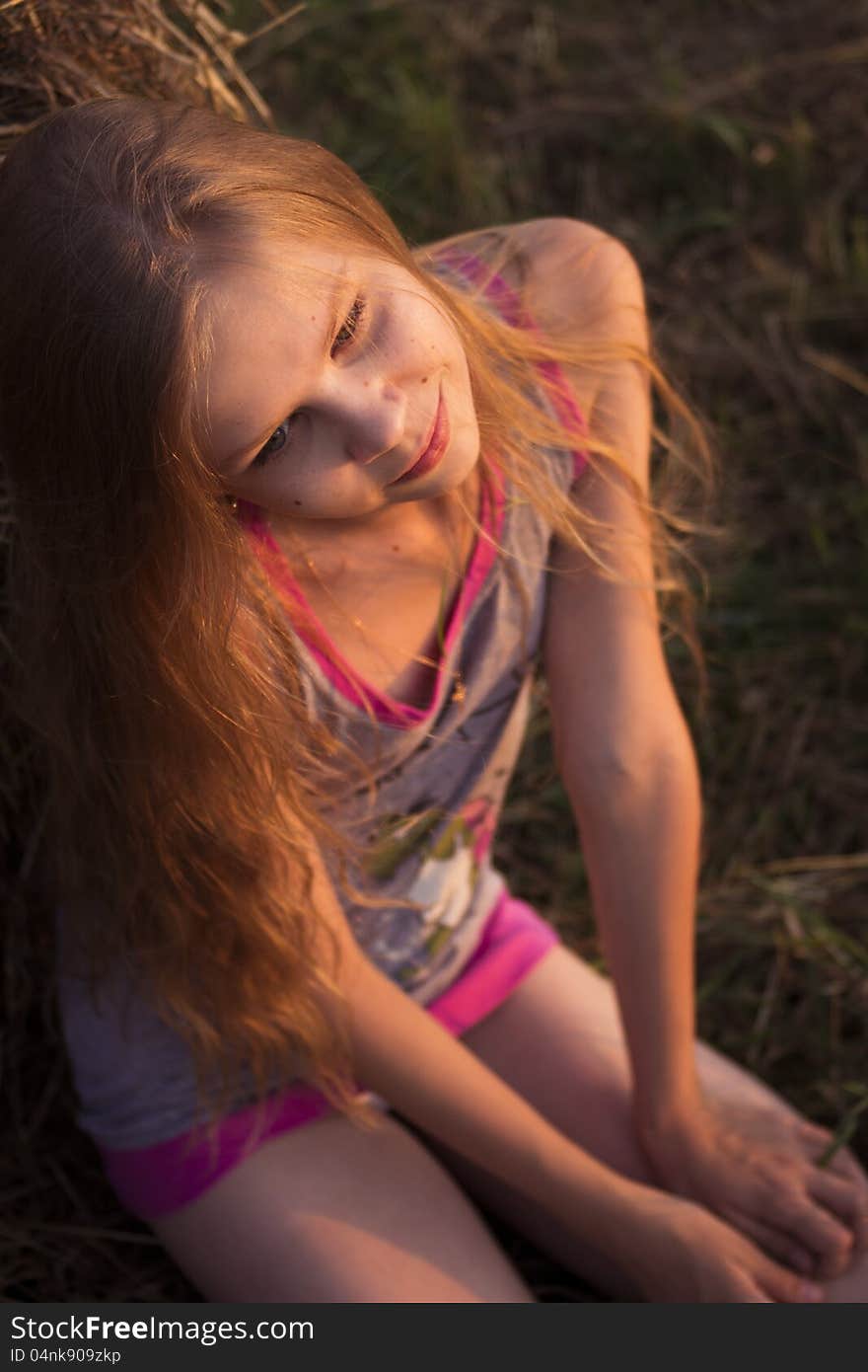 Portrait of teenage girl in the field with corn ears and straw