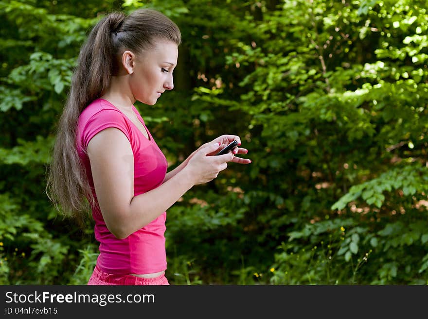 Beautiful girl with the phone walking forest. Beautiful girl with the phone walking forest