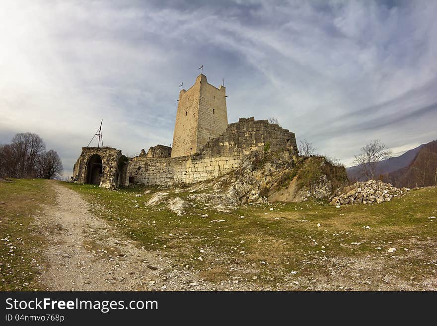 Ancient fortifications in the mountains in the rays of sunset. Genoese fortress