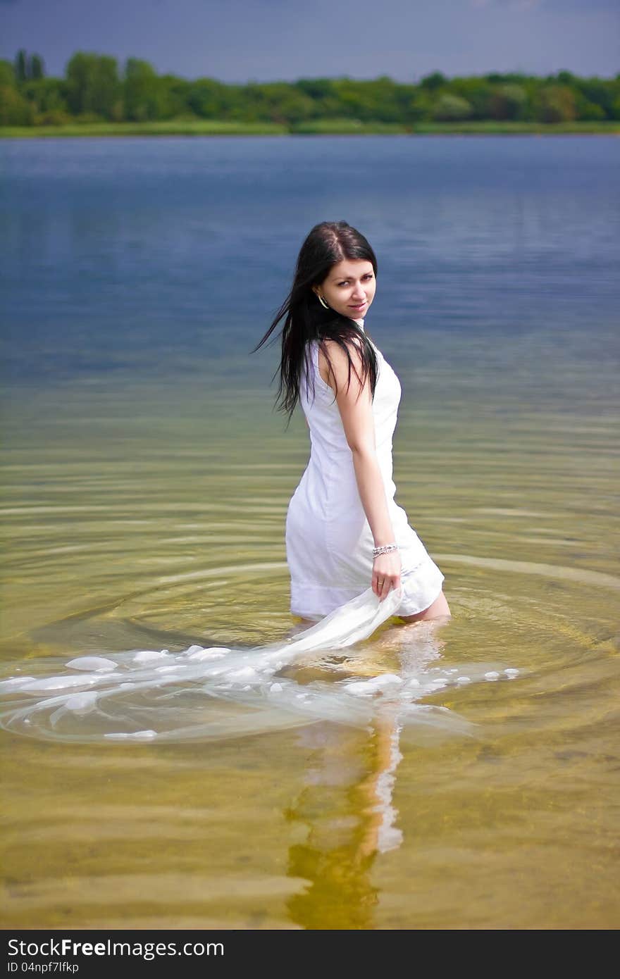 A beautiful brunette posing at a calm lake. A beautiful brunette posing at a calm lake