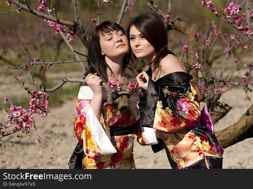 Girls in kimono and flowerses of the peach. Girls in kimono and flowerses of the peach