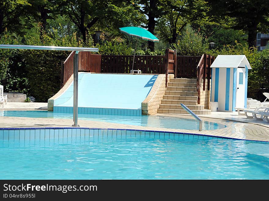 Limpid swimming pool and a waterslide without people