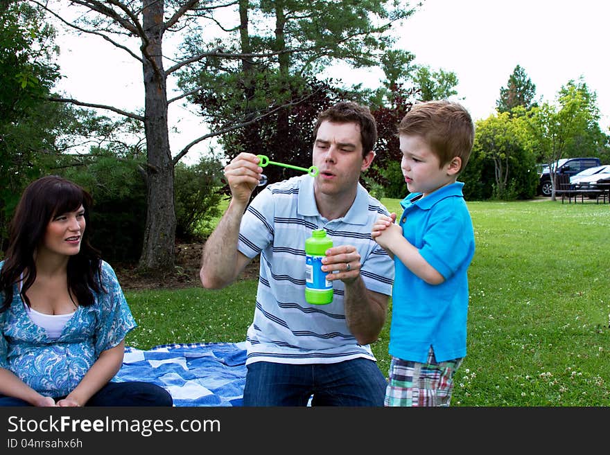 Dad teaching son to blow bubbles. Dad teaching son to blow bubbles