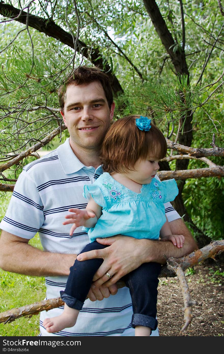 Dad holding daughter in tree. Dad holding daughter in tree