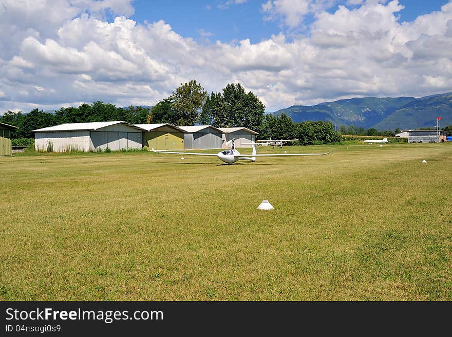 Glider or motor glider takes off from white grass runway to fly. Glider or motor glider takes off from white grass runway to fly