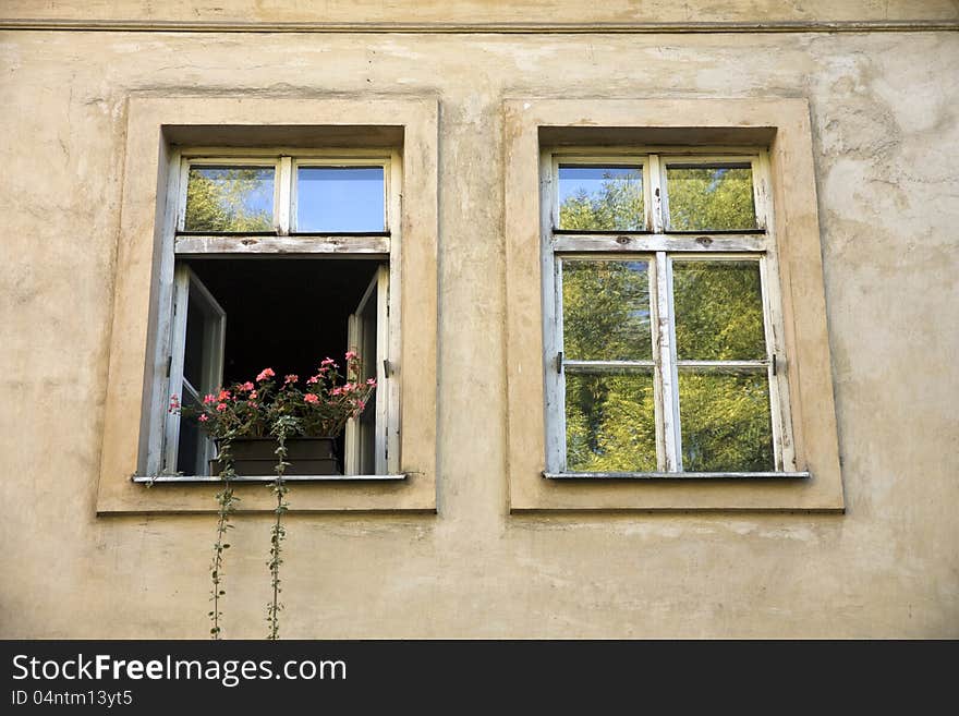 Open window with a flower on the windowsill, one open and one closed window. Open window with a flower on the windowsill, one open and one closed window