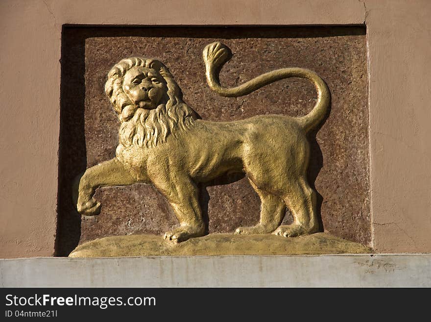 Detail yellow lion carved on the wall of the house. Detail yellow lion carved on the wall of the house