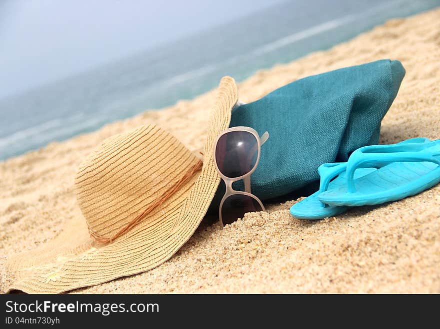 Summer holidays - blue beach bag on the seacoast and straw hat