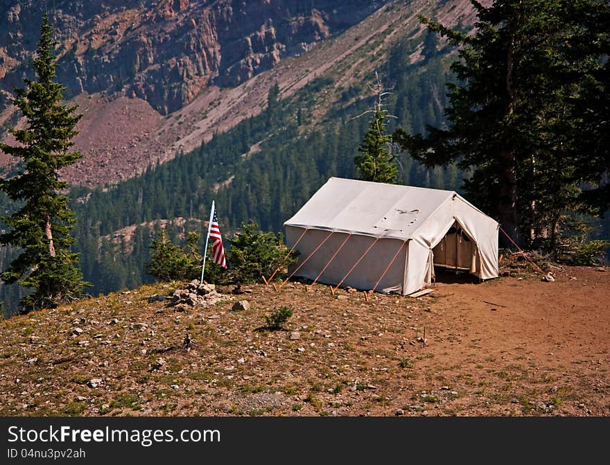 Camp with American flag on a cliff in the mountains. Camp with American flag on a cliff in the mountains