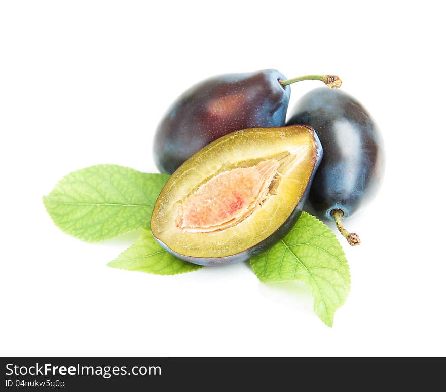 Plums with green leaves on a white background